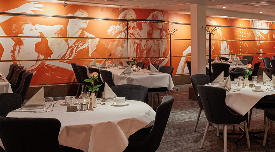 Bord och stolar i en restaurang med stämningsfull belysning.