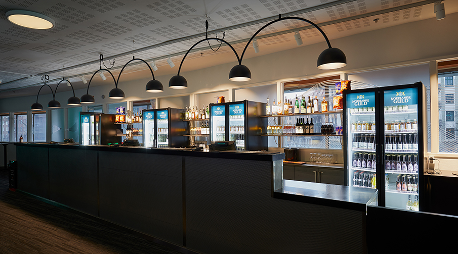 En bar med kylar fylld av drycker.