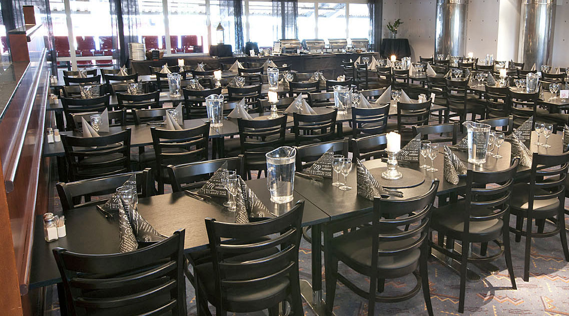 En lokal med flera rader med svarta bord och stolar.