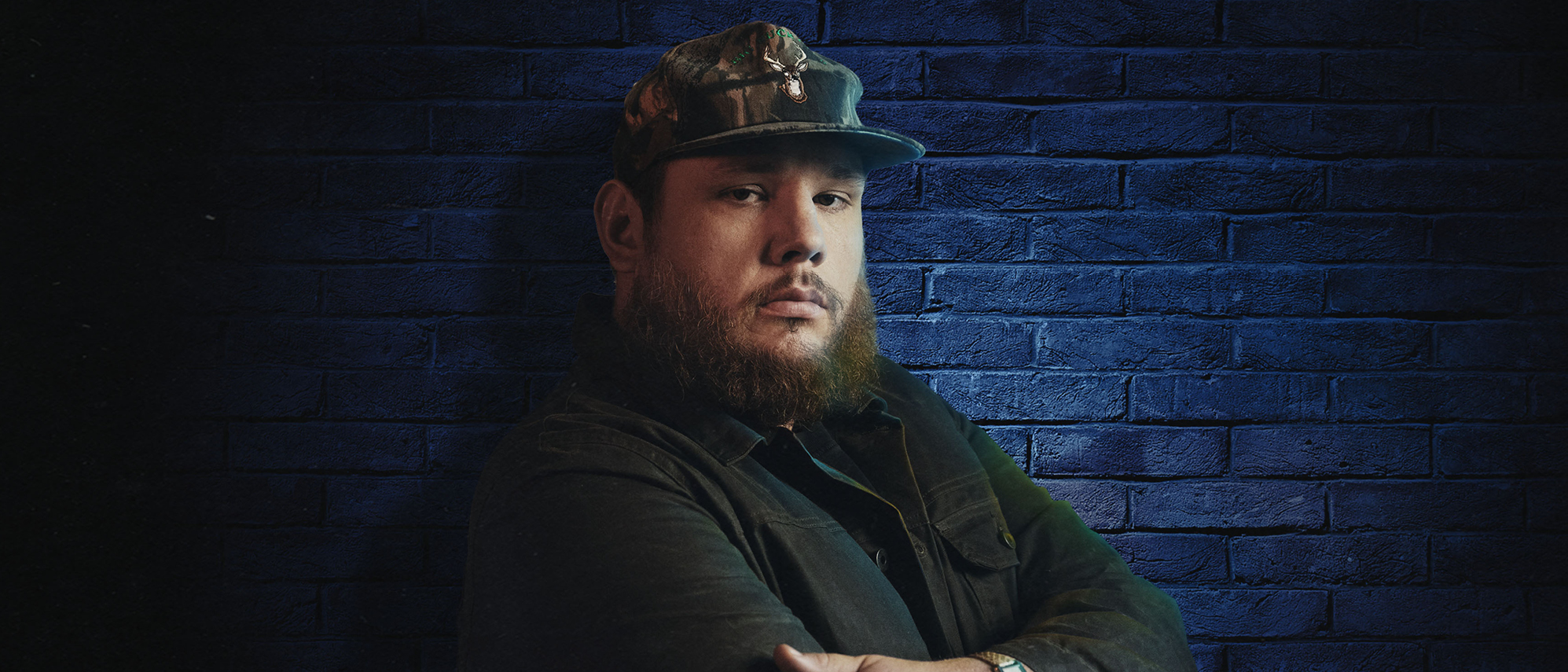 Luke Combs lutar mot en blå vägg.