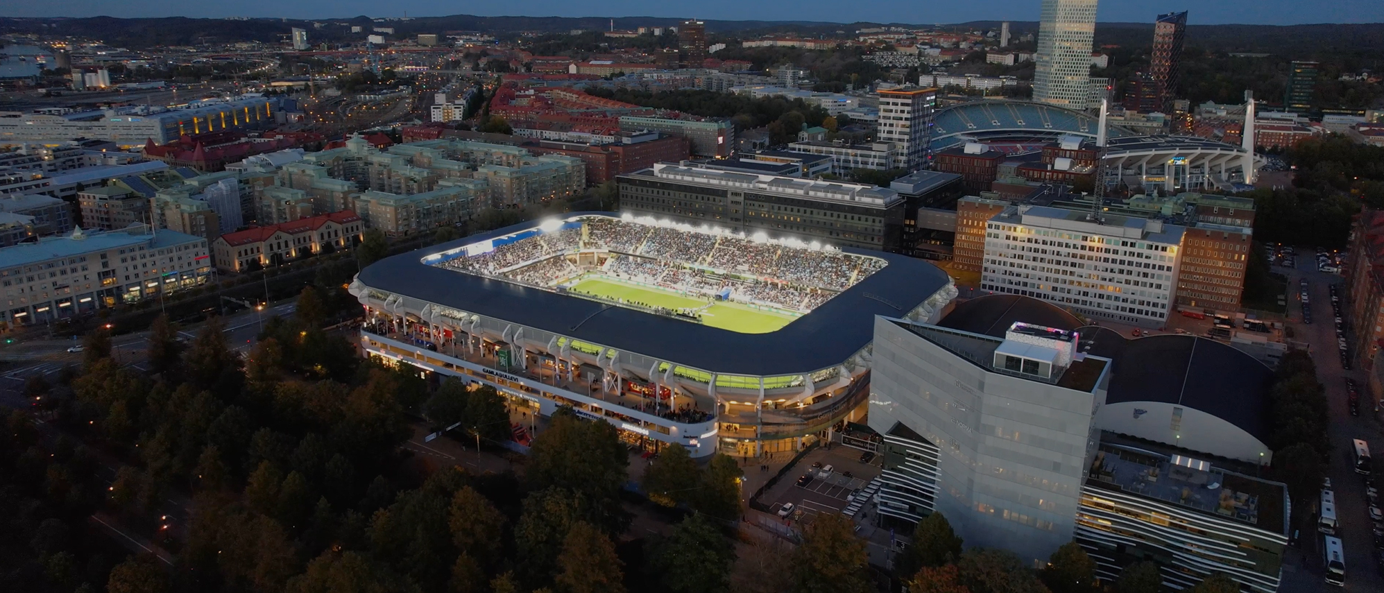 Gamla Ullevi från ovan. En match pågår på arenan och läktarna är fulla. I bakgrunden syns Ullevi.