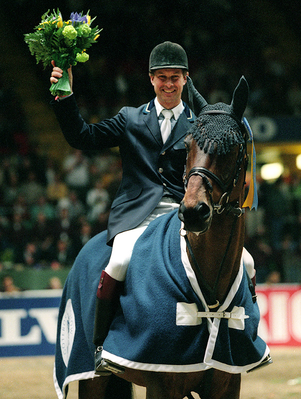 Rolf Göran Bengtsson sitter på hästen Paradisio och håller upp en segerbukett.