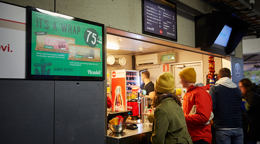 Besökare som köper mat och dryck ur en av kioskerna på Gamla Ullevi.