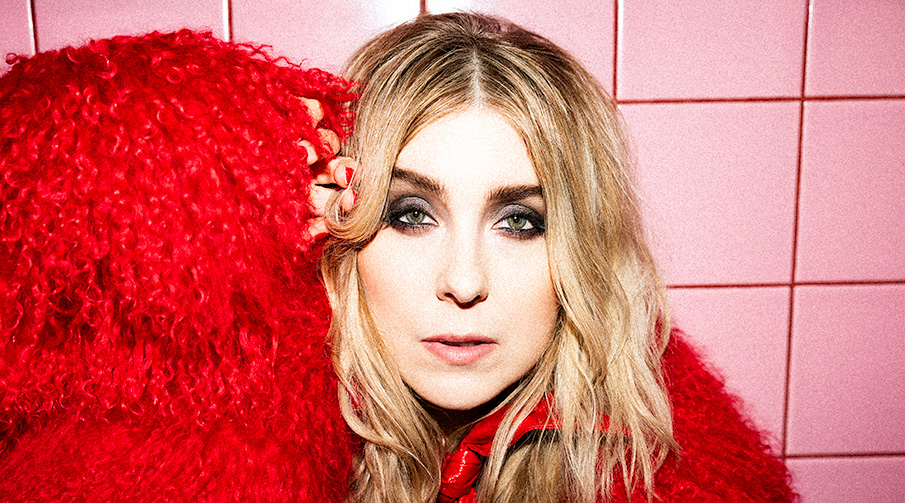 Miss Li mot en rosa kakelvägg. 